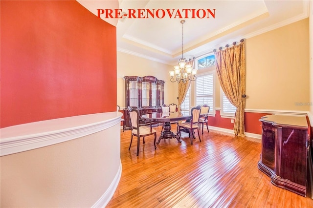 25813 Feather Ridge Ln, Sorrento, FL 32776 - dining area featuring a raised ceiling, a chandelier, ornamental molding, and light wood-type flooring