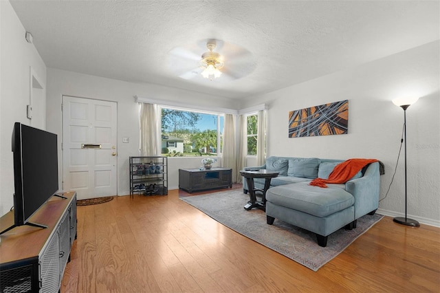 926 Mayfair Cir, Orlando, FL 32803 - living room featuring a ceiling fan, light wood-style flooring, baseboards, and a textured ceiling