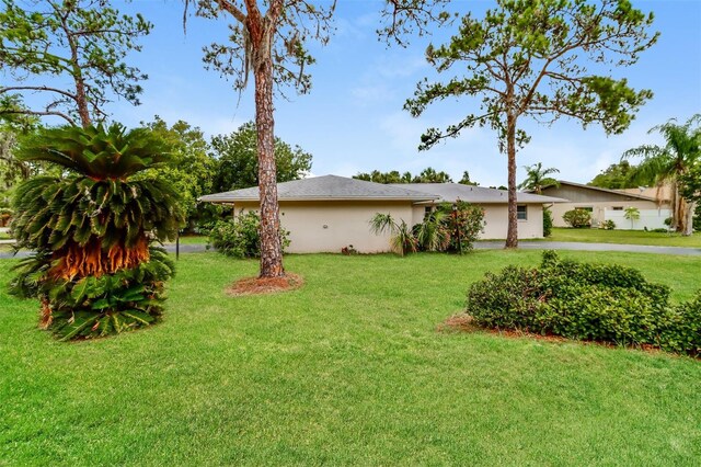 4337 Marine Pkwy, New Port Richey, FL 34652 - view of home's exterior featuring concrete driveway, stucco siding, and a lawn