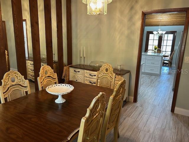 1500 Markham Woods Rd, Longwood, FL 32779 - dining area featuring baseboards, wood finished floors, and an inviting chandelier