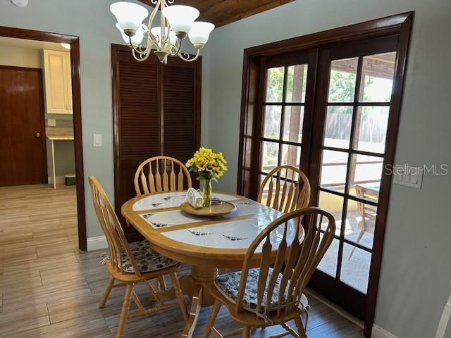 1500 Markham Woods Rd, Longwood, FL 32779 - dining area featuring light wood finished floors, baseboards, and an inviting chandelier