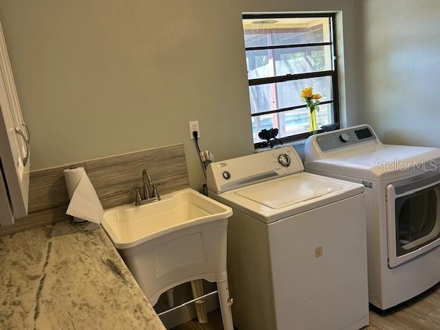 1500 Markham Woods Rd, Longwood, FL 32779 - laundry area featuring independent washer and dryer, a sink, light wood-style floors, and laundry area