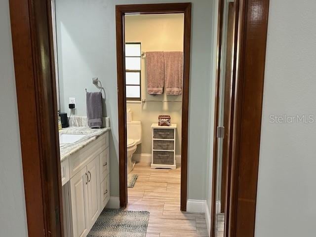 1500 Markham Woods Rd, Longwood, FL 32779 - bathroom featuring toilet, vanity, baseboards, and wood finished floors