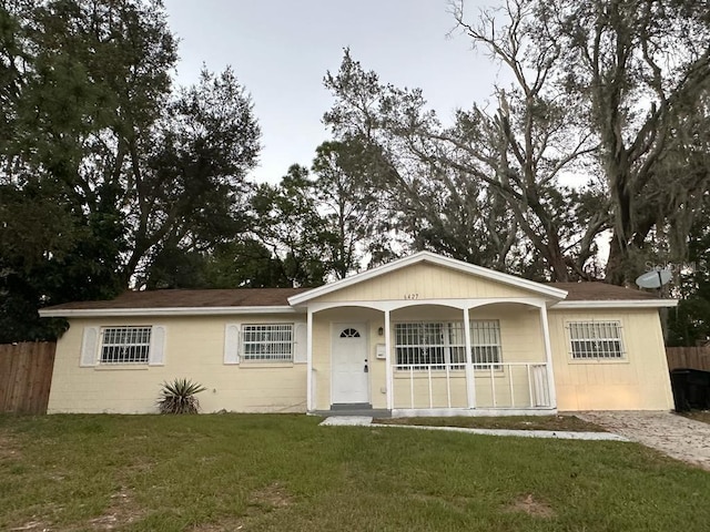 6427 Breezewood St, Orlando, FL 32818 - single story home featuring a porch, concrete block siding, a front yard, and fence
