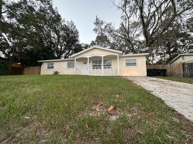 6427 Breezewood St, Orlando, FL 32818 - ranch-style house featuring driveway, covered porch, fence, and a front lawn