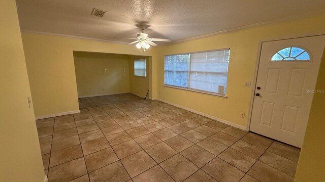 6427 Breezewood St, Orlando, FL 32818 - tiled entrance foyer featuring a ceiling fan, crown molding, a textured ceiling, and visible vents