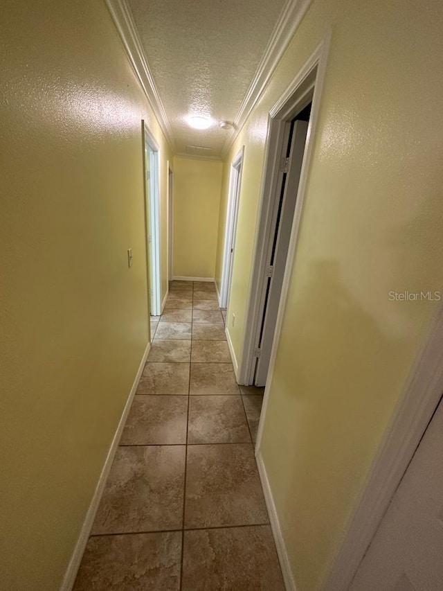 6427 Breezewood St, Orlando, FL 32818 - hallway featuring baseboards, light tile patterned floors, a textured ceiling, and ornamental molding