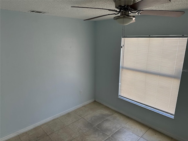 214 Magellan Dr, Kissimmee, FL 34758 - empty room with light tile patterned flooring, a textured ceiling, visible vents, baseboards, and ceiling fan