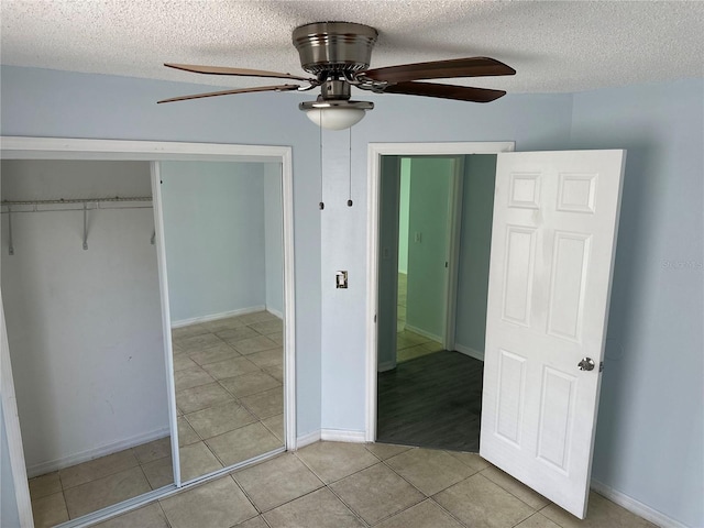 214 Magellan Dr, Kissimmee, FL 34758 - unfurnished bedroom featuring a closet, a textured ceiling, ceiling fan, and light tile patterned floors