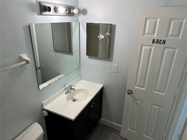 214 Magellan Dr, Kissimmee, FL 34758 - bathroom featuring baseboards, toilet, vanity, and wood finished floors