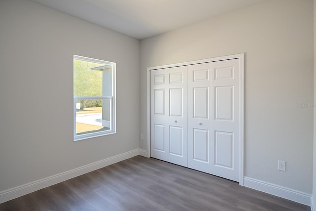 8830 N Salina Dr, Citrus Springs, FL 34434 - unfurnished bedroom featuring dark wood-style floors and a closet