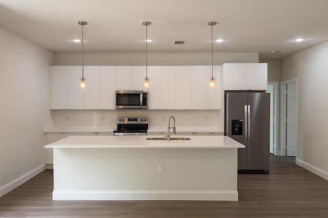 8830 N Salina Dr, Citrus Springs, FL 34434 - kitchen with stainless steel appliances, an island with sink, dark wood-style floors, light countertops, and white cabinetry