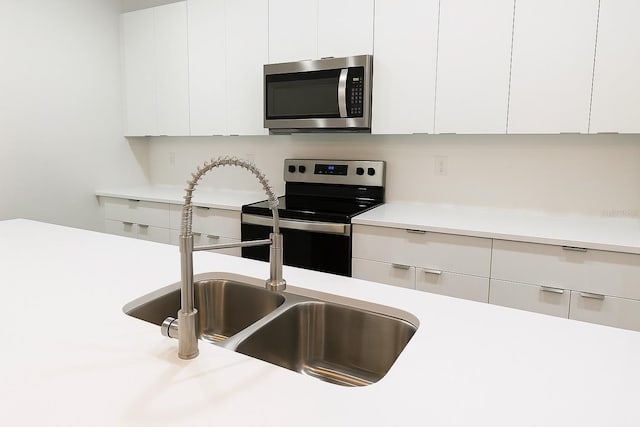8830 N Salina Dr, Citrus Springs, FL 34434 - kitchen featuring stainless steel appliances, light countertops, modern cabinets, and white cabinetry