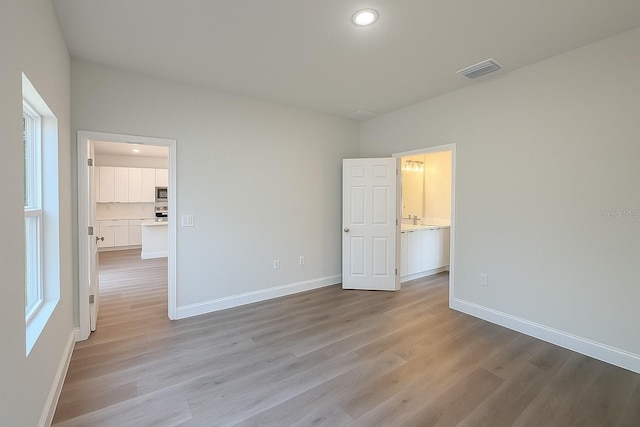 8830 N Salina Dr, Citrus Springs, FL 34434 - unfurnished bedroom featuring light wood-style floors and recessed lighting