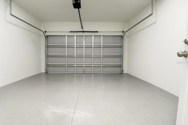 8830 N Salina Dr, Citrus Springs, FL 34434 - garage featuring a garage door opener and concrete block wall