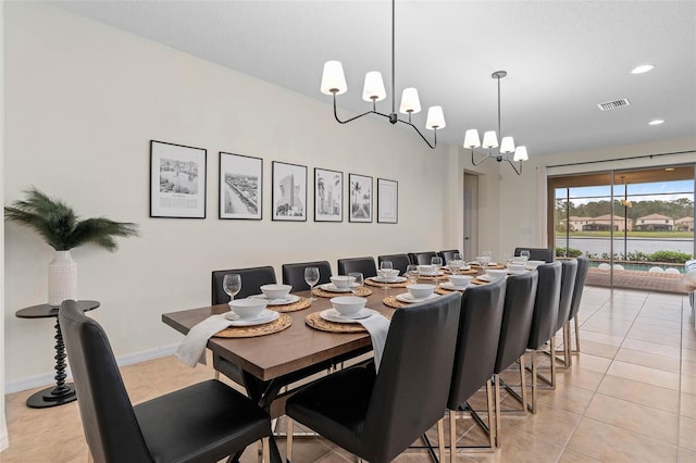 dining area with baseboards, visible vents, a chandelier, and light tile patterned floors
