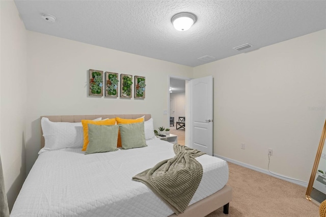 bedroom with baseboards, a textured ceiling, visible vents, and light carpet