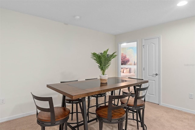 dining room with light colored carpet and baseboards