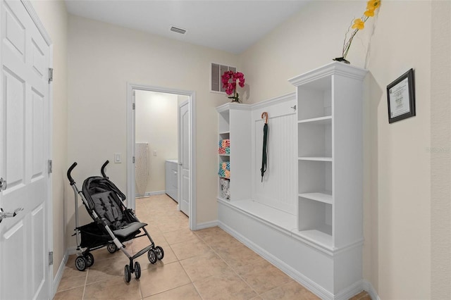 mudroom featuring light tile patterned flooring, baseboards, visible vents, and washer / clothes dryer