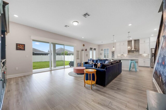 2011 Soaring Oak Way, Winter Park, FL 32792 - living room featuring light wood-type flooring, recessed lighting, baseboards, and visible vents