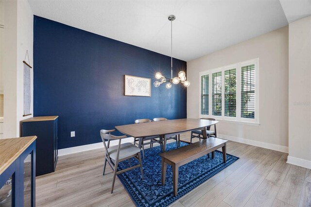 2011 Soaring Oak Way, Winter Park, FL 32792 - dining room with light wood finished floors, an inviting chandelier, baseboards, and an accent wall