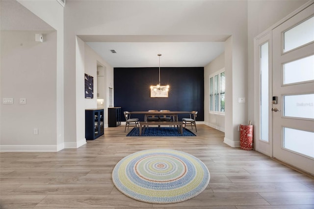 2011 Soaring Oak Way, Winter Park, FL 32792 - dining area featuring light wood finished floors, visible vents, baseboards, an accent wall, and a chandelier