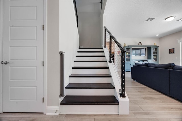 2011 Soaring Oak Way, Winter Park, FL 32792 - stairs featuring a textured ceiling, visible vents, and wood finished floors