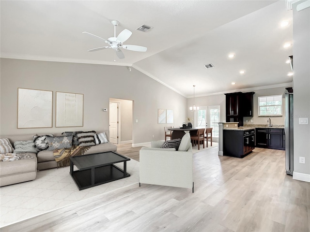 509 Mulberry St, Fruitland Park, FL 34731 - living room featuring lofted ceiling, visible vents, light wood-style floors, and ceiling fan with notable chandelier