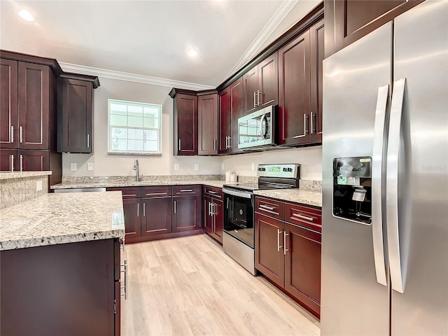 509 Mulberry St, Fruitland Park, FL 34731 - kitchen with recessed lighting, ornamental molding, stainless steel appliances, a sink, and light wood-style floors