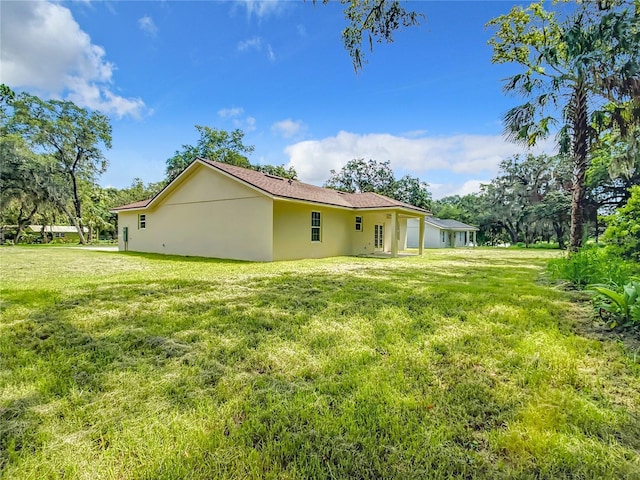 509 Mulberry St, Fruitland Park, FL 34731 - rear view of house with stucco siding and a lawn