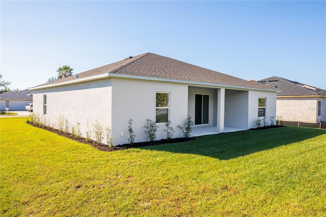 25372 Alicante Dr, Punta Gorda, FL 33955 - back of house featuring a shingled roof, a lawn, and stucco siding