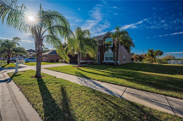 31028 Baclan Dr, Wesley Chapel, FL 33545 - view of property hidden behind natural elements with stucco siding, concrete driveway, and a front yard