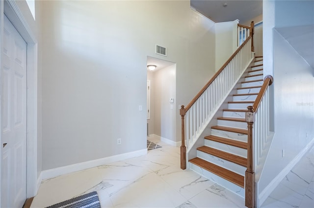 31028 Baclan Dr, Wesley Chapel, FL 33545 - stairs featuring a high ceiling, marble finish floor, baseboards, and visible vents