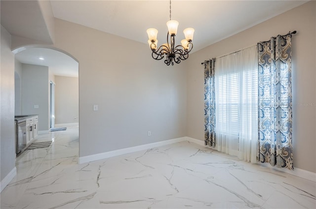 31028 Baclan Dr, Wesley Chapel, FL 33545 - spare room with an inviting chandelier, marble finish floor, arched walkways, and baseboards