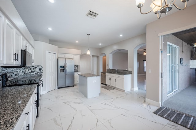 31028 Baclan Dr, Wesley Chapel, FL 33545 - kitchen featuring visible vents, marble finish floor, stainless steel appliances, a sink, and a center island