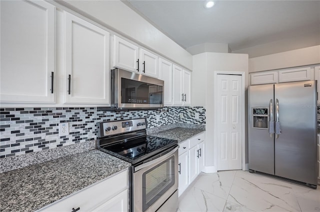 31028 Baclan Dr, Wesley Chapel, FL 33545 - kitchen with white cabinetry, marble finish floor, appliances with stainless steel finishes, and dark stone countertops