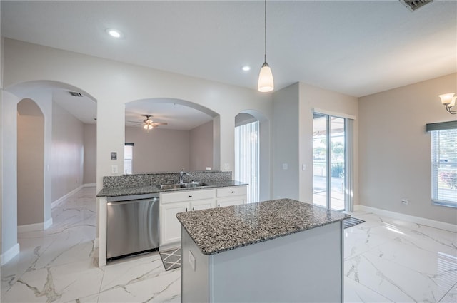 31028 Baclan Dr, Wesley Chapel, FL 33545 - kitchen with stainless steel dishwasher, marble finish floor, dark stone countertops, and a sink