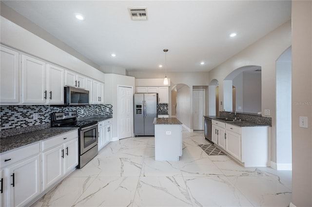 31028 Baclan Dr, Wesley Chapel, FL 33545 - kitchen with tasteful backsplash, stainless steel appliances, marble finish floor, a kitchen island, and visible vents