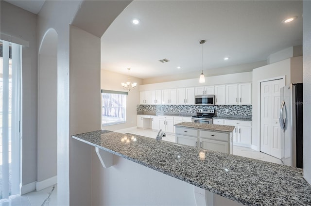 31028 Baclan Dr, Wesley Chapel, FL 33545 - kitchen with marble finish floor, light stone countertops, decorative backsplash, and appliances with stainless steel finishes