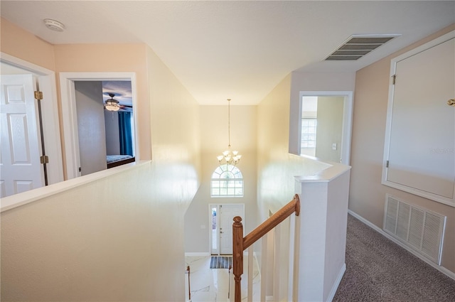 31028 Baclan Dr, Wesley Chapel, FL 33545 - hall featuring carpet flooring, an upstairs landing, visible vents, and an inviting chandelier
