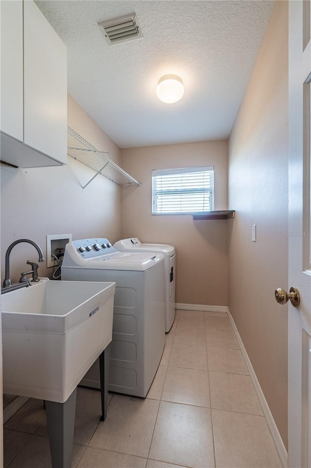 31028 Baclan Dr, Wesley Chapel, FL 33545 - laundry area featuring washer and clothes dryer, a sink, light tile patterned floors, visible vents, and cabinet space