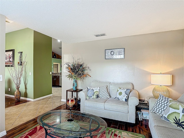 556 Hummingbird Ct, Kissimmee, FL 34759 - living room featuring tile patterned flooring, a textured ceiling, baseboards, and visible vents