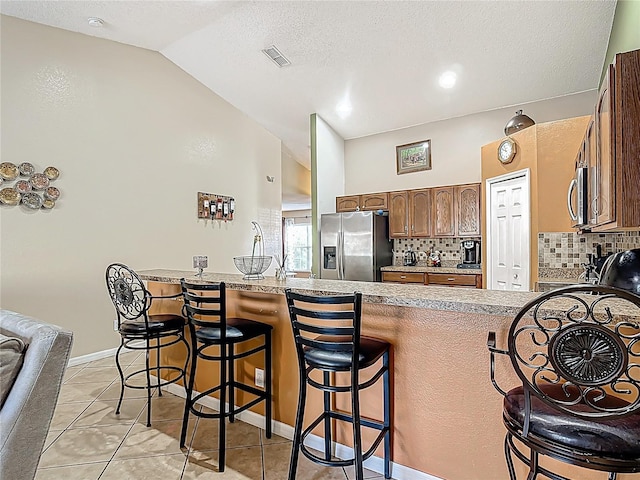 556 Hummingbird Ct, Kissimmee, FL 34759 - kitchen featuring visible vents, backsplash, a peninsula, and appliances with stainless steel finishes
