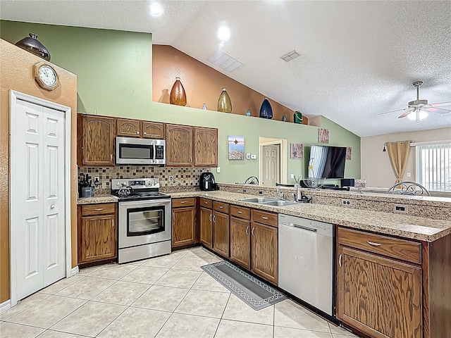 556 Hummingbird Ct, Kissimmee, FL 34759 - kitchen featuring visible vents, a peninsula, appliances with stainless steel finishes, a sink, and light tile patterned floors