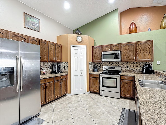 556 Hummingbird Ct, Kissimmee, FL 34759 - kitchen featuring light countertops, light tile patterned floors, backsplash, a sink, and appliances with stainless steel finishes