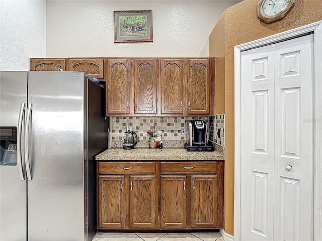 556 Hummingbird Ct, Kissimmee, FL 34759 - kitchen with tasteful backsplash, light countertops, a textured wall, and stainless steel refrigerator with ice dispenser