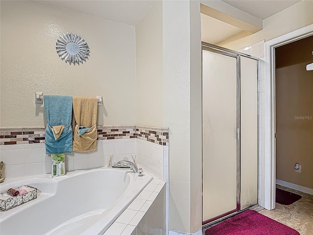 556 Hummingbird Ct, Kissimmee, FL 34759 - full bathroom featuring a shower stall, tile patterned floors, a textured wall, and a garden tub