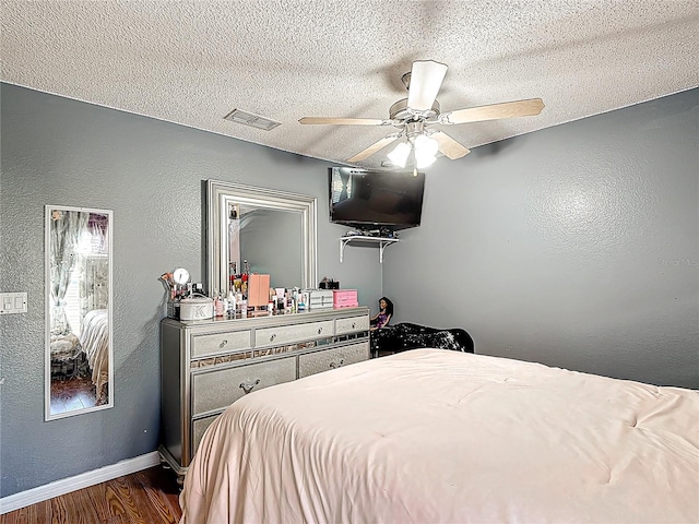 556 Hummingbird Ct, Kissimmee, FL 34759 - bedroom featuring a textured ceiling, visible vents, baseboards, dark wood-type flooring, and a textured wall