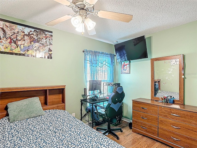 556 Hummingbird Ct, Kissimmee, FL 34759 - bedroom with light wood finished floors, ceiling fan, and a textured ceiling