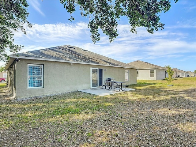556 Hummingbird Ct, Kissimmee, FL 34759 - rear view of house featuring a lawn, stucco siding, and a patio area